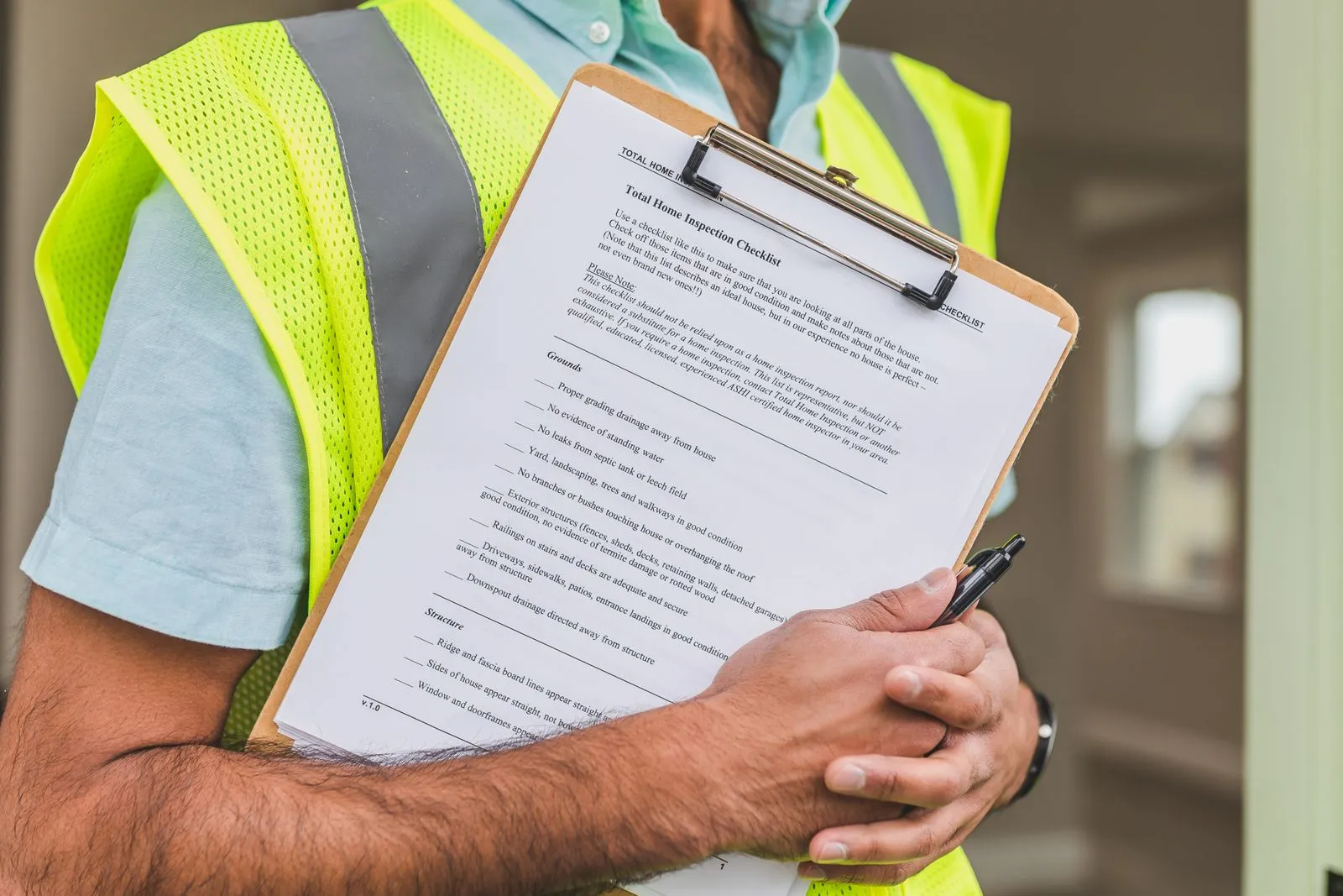 Close-up of a home inspection checklist on a clipboard, pen in hand